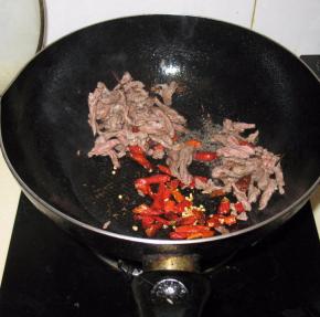 肉丝炒至变色后加入干辣椒，翻炒