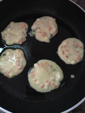 平底锅热油，用勺子舀一点面糊在锅里