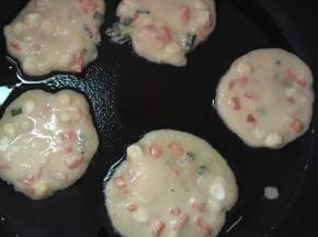 平底锅热油，用勺子舀一点面糊在锅里