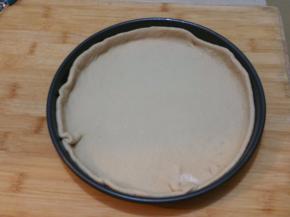 擀成跟圆形面片，放入烤盘内，饼皮四周稍微高出一点点