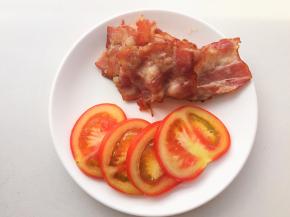 培根片煎至金黄，番茄切片，生菜洗净擦干