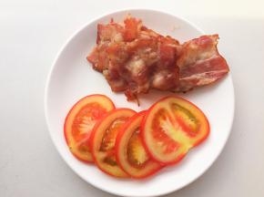 培根片煎至金黄，番茄切片，生菜洗净擦干