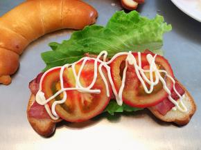 在牛角包挤上蛋黄酱，放上生菜，培根，番茄，再挤上蛋黄酱