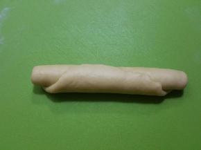 取其中一份面团擀长从侧面卷起，然后用手指把收口出捏紧封好