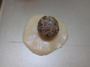 取一个饼皮，按压成圆饼，将五仁馅放在上面