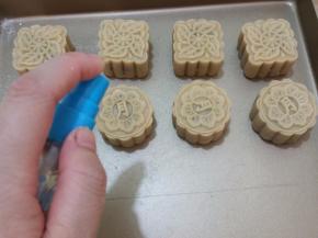 在面团上抹一层面粉，将其放入模具中，按压出花纹即可，表面喷水，送入预热200度的烤箱烤5分钟，至花纹定型