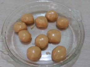 将转化糖浆倒入。 加入花生油（色拉油）搅拌均匀，再放入枧水，搅拌均匀。筛入面粉和奶粉。 用刮刀，自上而下，用“切、切、切”的方式，不停地剁面。 和成面团，将面团放入保鲜袋静置1小时，饼皮分成25克每个