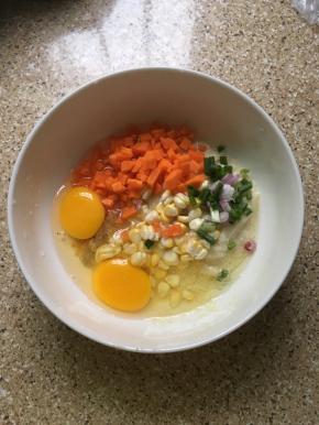 把豆渣、鸡蛋、切好的胡萝卜粒、葱花，玉米粒、盐、胡椒粉放在碗里