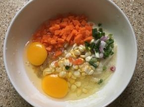 把豆渣、鸡蛋、切好的胡萝卜粒、葱花，玉米粒、盐、胡椒粉放在碗里