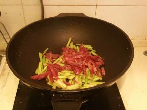 放入腊肠丝，炒至变颜色，时间长腊肠避免肉质过硬