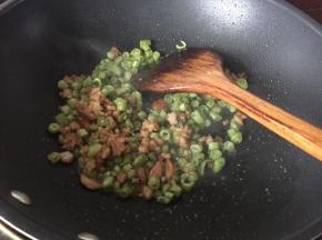 加入蚝油炒均匀后放入菜豆炒，最后加入盐翻炒均匀即可