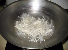 金针蘑洗浄去掉根锅中加入水烧热倒入金针蘑煮熟