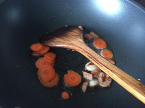 然后放入胡萝卜薄片翻炒