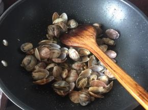 然后放入花甲炒，加入葱姜料酒