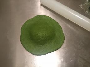 取一小块，擀成中间厚边缘薄的圆片，小刀对切4刀，留中间凸起处不切断