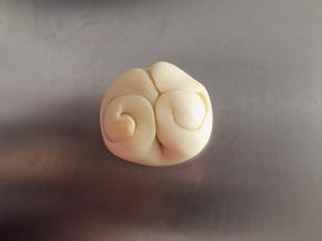 取一份酥皮，中指从中间压下，两边向中间卷好（如图）