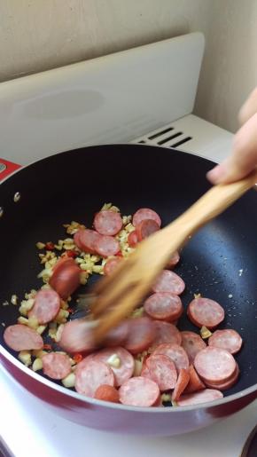 等大蒜有点金黄色再加入香肠，煎一下。