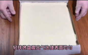 其他白色面糊装入放了油纸的28×28金盘，摔出气泡，烤箱预热165度