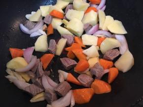 加入土豆和胡萝卜块翻炒。