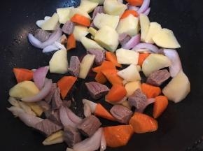 加入土豆和胡萝卜块翻炒。