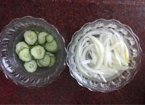 黄瓜擦成薄片，洋葱切丝，分别用盐水浸泡10分钟