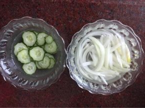 黄瓜擦成薄片，洋葱切丝，分别用盐水浸泡10分钟