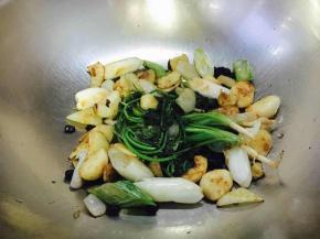 热锅凉油，小火先煸炒蒜粒、姜片、洋葱，煸炒约4～5分钟后蒜发浅金黄色时改中火再放入葱和香菜、冰糖一起煸炒，煸炒至葱有焦糊色，冰糖软化，如图所示。