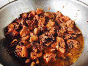 当炖20分钟后打开锅盖儿，把料包和香菜等调料挑出来扔掉，翻炒几下鸡块，使它上色均匀，这时注意要调一调味，翻炒后就是图片上的这种颜色，这时再用大火炖5分钟左右，卤汁也会更浓稠些，此时关火，盖上锅盖儿焖半个小时左右即可。