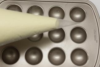 做好的面糊装在裱花袋里面，底下剪个口，再挤到棒棒糖模具里面