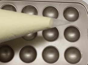做好的面糊装在裱花袋里面，底下剪个口，再挤到棒棒糖模具里面