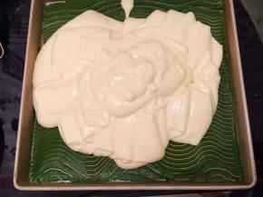 蛋清和蛋黄糊分2次上下翻拌均匀，倒入一抹茶糊的金盘内，左右晃动均匀后轻震去气泡