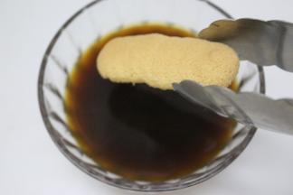 把黑咖啡和朗姆酒拌匀，手指饼干在混合好的咖啡液里滚一下备用