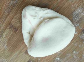 白色面团分成两份或者三份，我做的大馒头，所以分成了两份，取一个面团开始揉至表面光滑有透亮感且切开面团断面没气泡，面团揉好