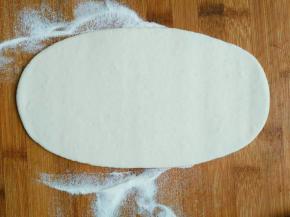 取一个小剂子擀成长方形或者牛舌状，然后在中间用刷子刷一层薄油，注意边缘不要刷，因为一会还要沾合做成口袋的形状