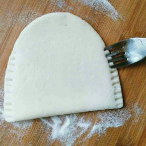 面片对折，并借助工具把两边压紧在一起，口袋饼完成