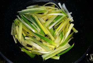 锅中倒入玉米油。油最好要没过葱段；油温热时下葱段，全程小火熬制；