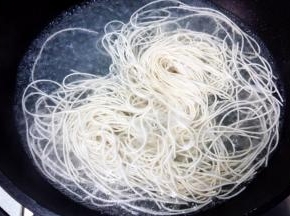 另起一锅，倒入适量水，烧开后，下挂面。中途加两次凉水，再次煮开。将面条捞出。不喜欢热的的可以过下凉水。浇上熬好的葱油，拌匀开吃吧。