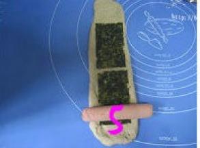 翻面，擀长，放上海苔片和火腿肠；