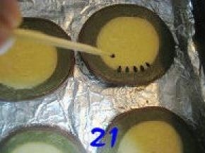 用牙签沾取黑芝麻，均匀地按在绿色与黄色面团交接处；