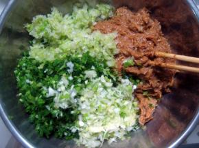 在腌好的肉馅中加入葱花、韭菜、白菜和少许盐拌匀；