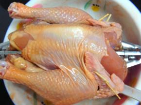 4、第二天从冰箱拿出用烤叉固定鸡身，鸡翅用牙签固定。