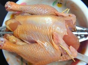 4、第二天从冰箱拿出用烤叉固定鸡身，鸡翅用牙签固定。