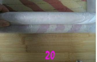 先将底部的蛋糕边卷一下，再用空出的油纸包住擀面杖，擀面杖朝身前卷油纸，边卷边提起擀面杖推动蛋糕向外卷起；