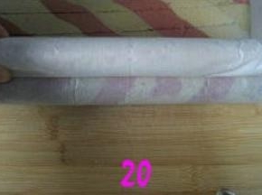 先将底部的蛋糕边卷一下，再用空出的油纸包住擀面杖，擀面杖朝身前卷油纸，边卷边提起擀面杖推动蛋糕向外卷起；
