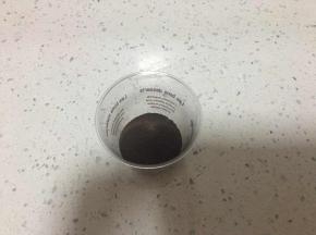 杯子里放一层饼干末，用勺子稍微压平