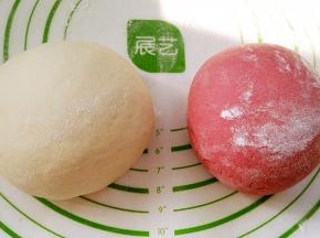 放揉面垫或案板上开始用拳头捣， 用掌跟揉、折叠，并重复此动作对面团进行排气，直到把面团揉光滑(分次撒少许干粉防粘)。