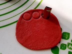取一个面剂擀开，用小花嘴压出圆形当猪鼻子。