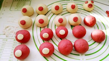 小圆面片背面用筷子抹水，逐个粘猪头上合适的位置当鼻子。