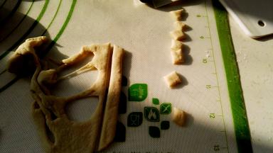 剩下的面片切分出猪耳朵（随便弄就可以，成品不会丑），面片背面用筷子抹水逐个粘猪头上当耳朵。