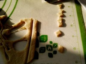 剩下的面片切分出猪耳朵（随便弄就可以，成品不会丑），面片背面用筷子抹水逐个粘猪头上当耳朵。